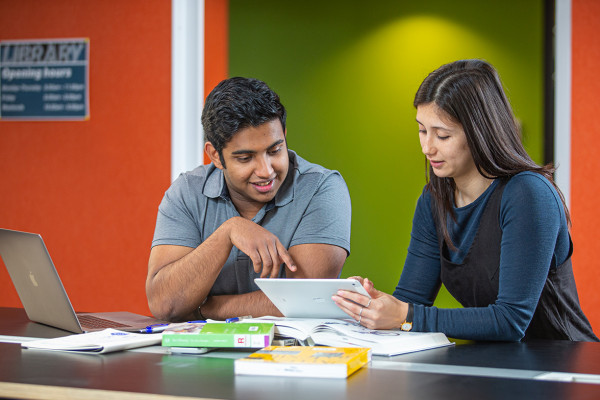Two individuals engaging in tablet-based reading.