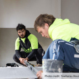 Two apprentices using a level