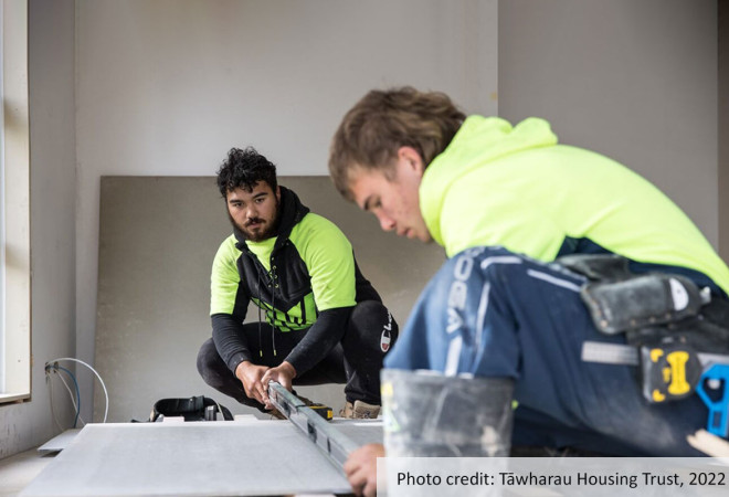 Two apprentices using a level