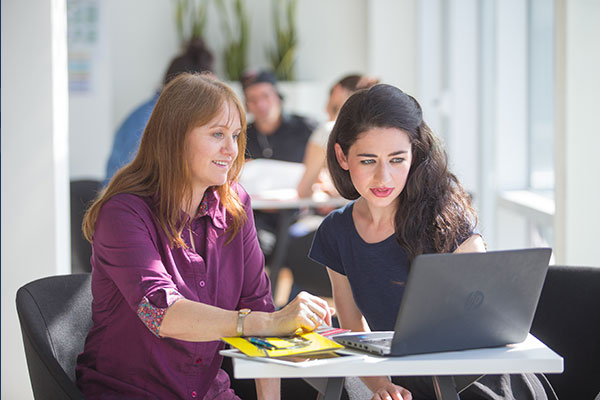 Two learners looking at the laptop