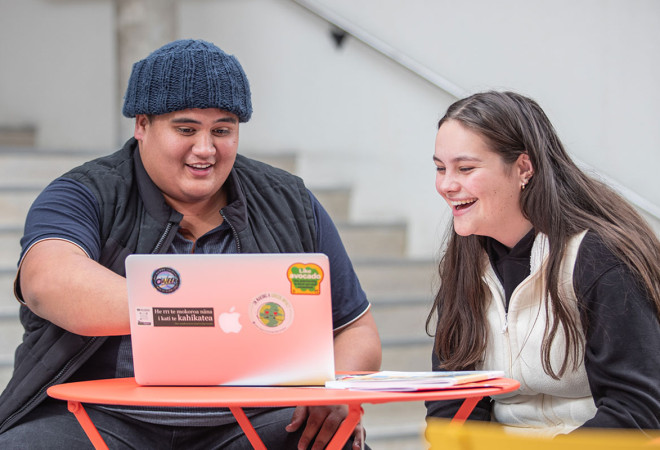 Two students viewing the laptop