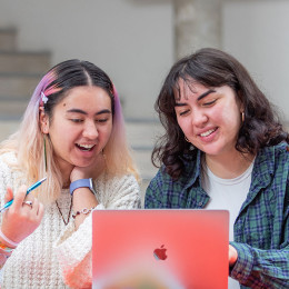 two tertiary students looking at the laptop