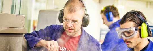 An instructor guiding a trainee in industrial tasks