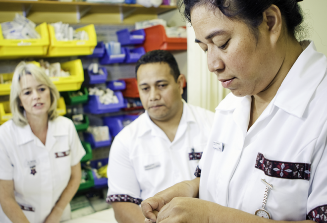 Nursing students work while a supervisor watches them