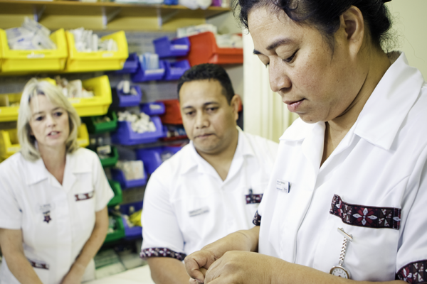 Nursing students work while a supervisor watches them