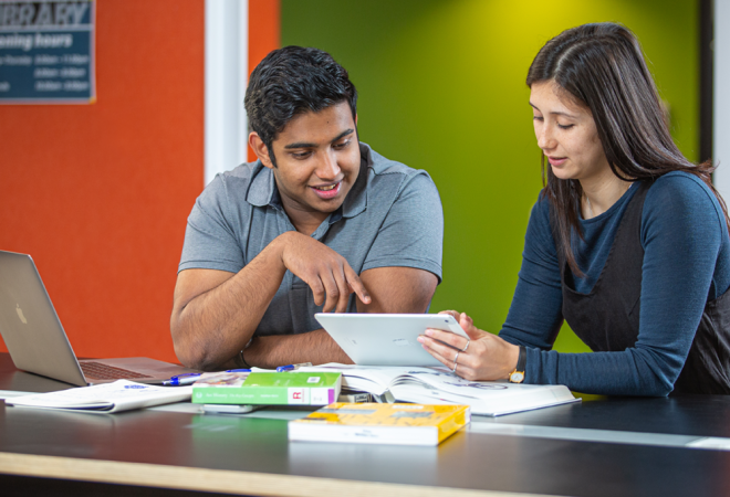 two staff discuss technology issues