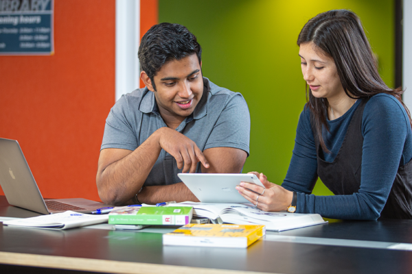 two staff discuss technology issues
